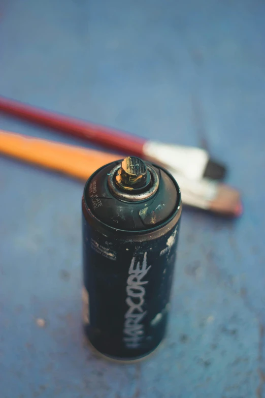 a small battery sitting next to a red and white brush