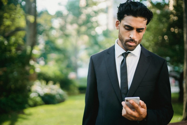 a man looking at a phone with one hand