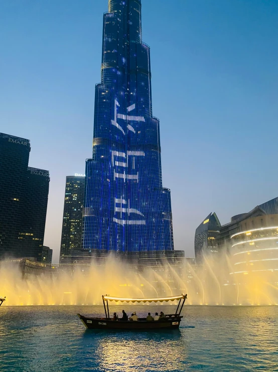 a boat near a big tower with water spraying from the water