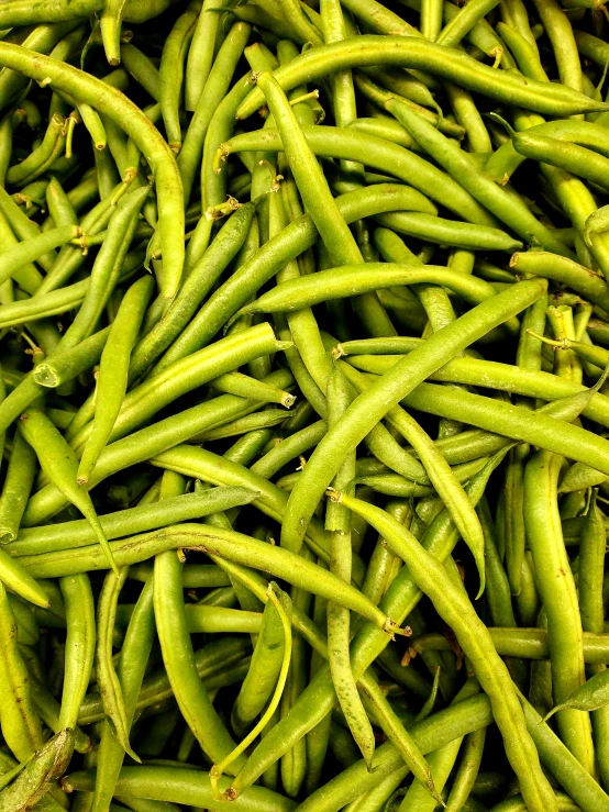 a pile of green beans with the skin showing