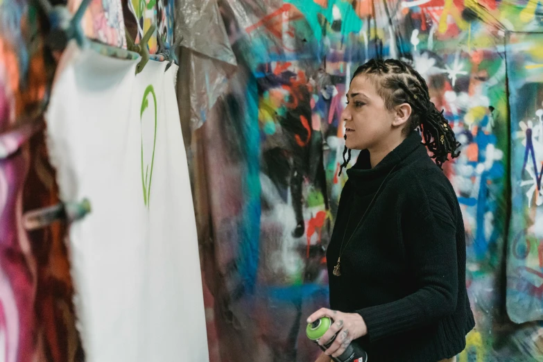 a man is standing next to a wall with graffiti