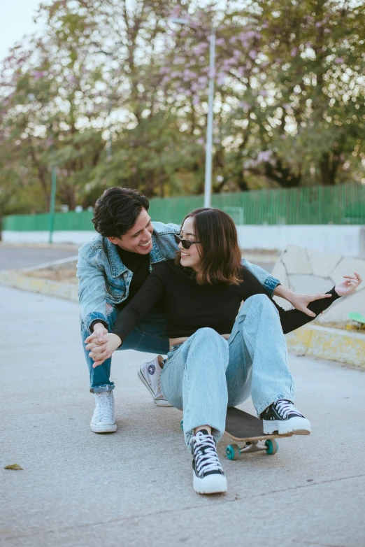 a couple riding on top of a skateboard