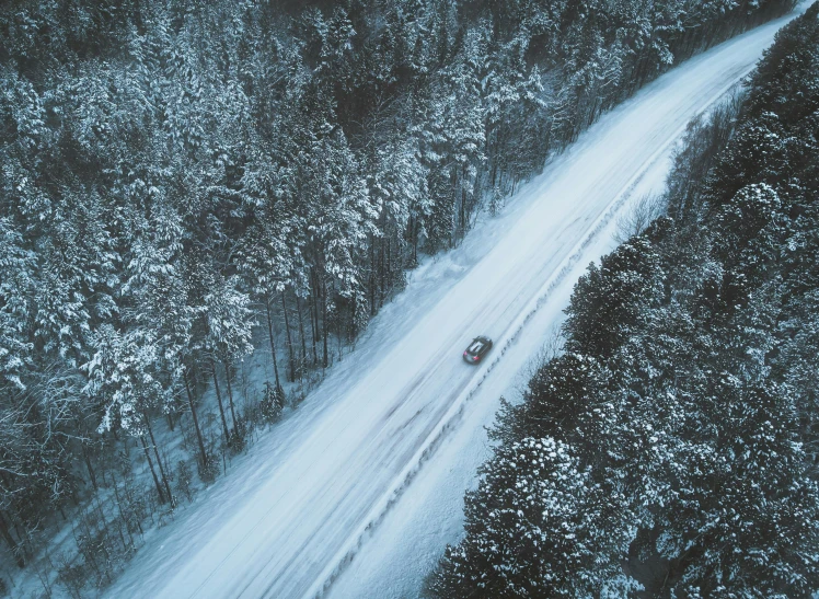 aerial view of snow covered roads with trees in the background