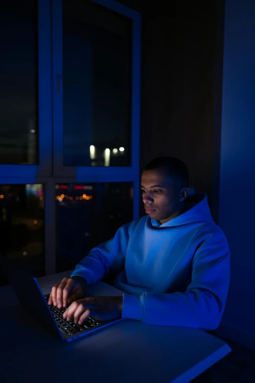 a man is using his laptop computer in the dark