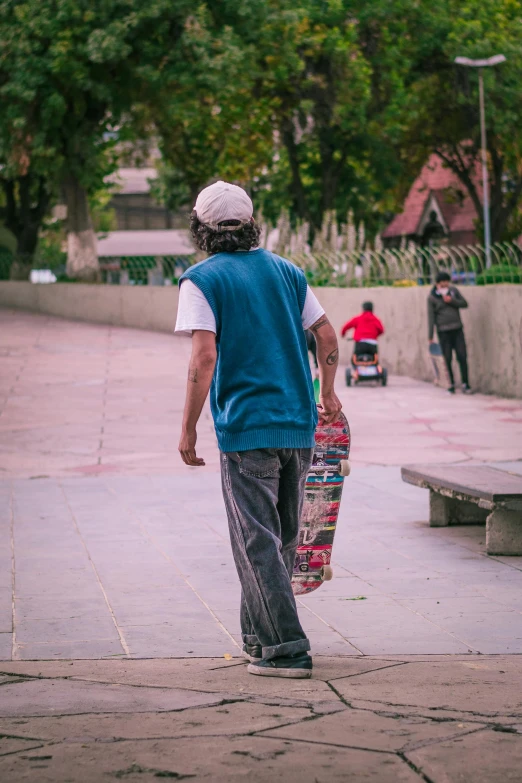 a young man carrying a skateboard on the street