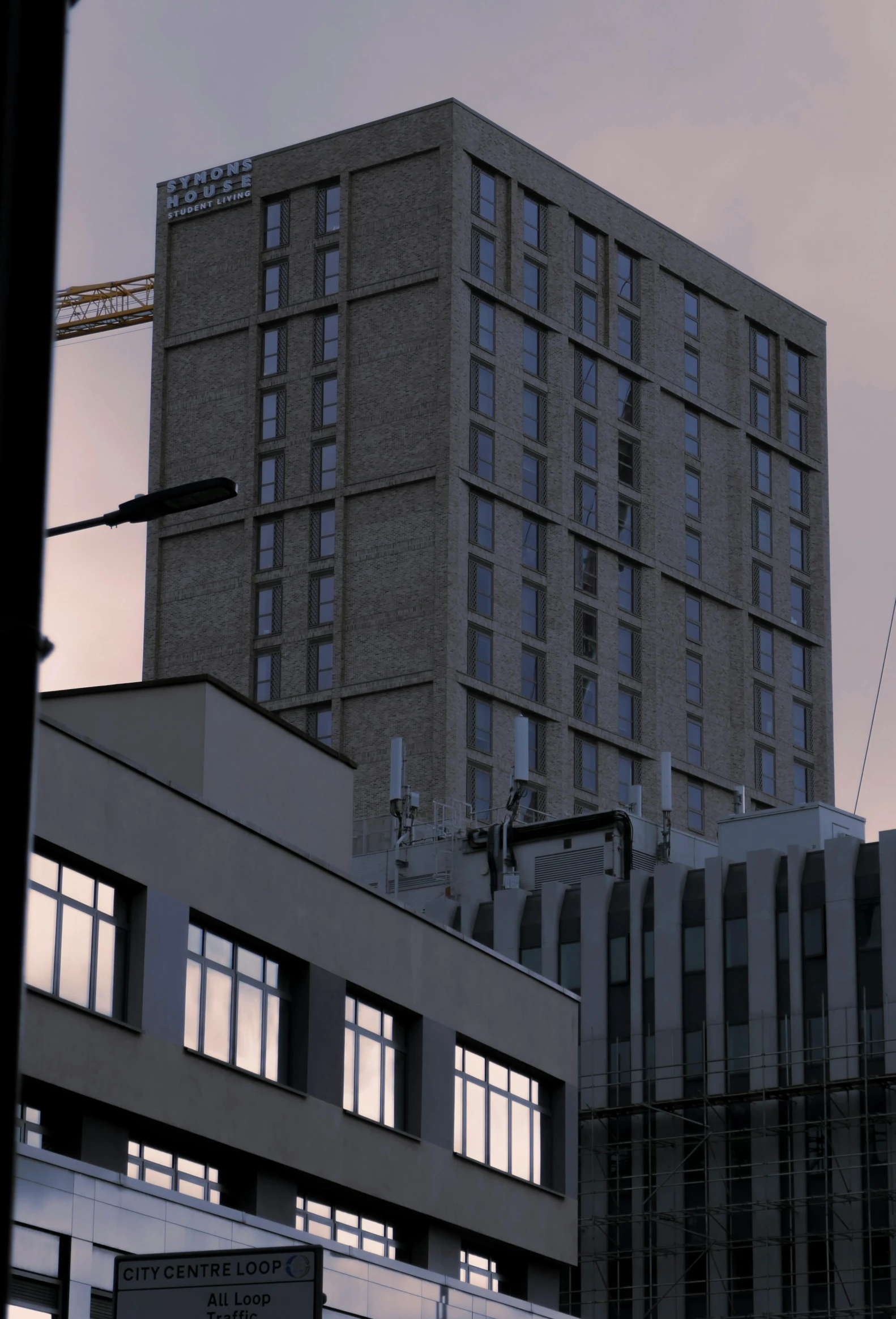 a large brown brick building with windows next to other buildings