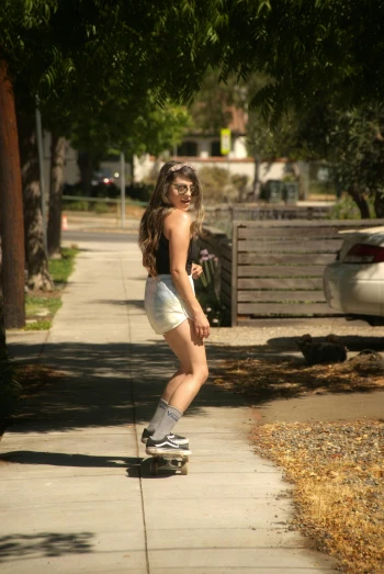 a girl is riding her skateboard down the sidewalk