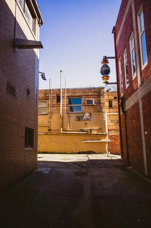 a red stop light in between two brick buildings