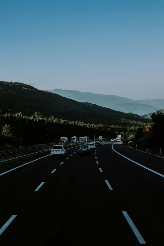 car driving down road in mountains area on a clear day