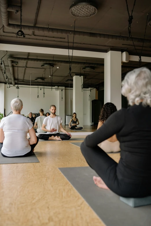 the group of older people are sitting on yoga mats