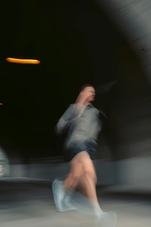 blurred motion pograph of man running in a tunnel