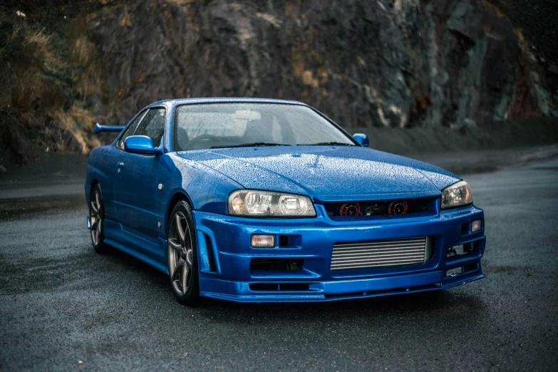 a blue car parked near a mountain side