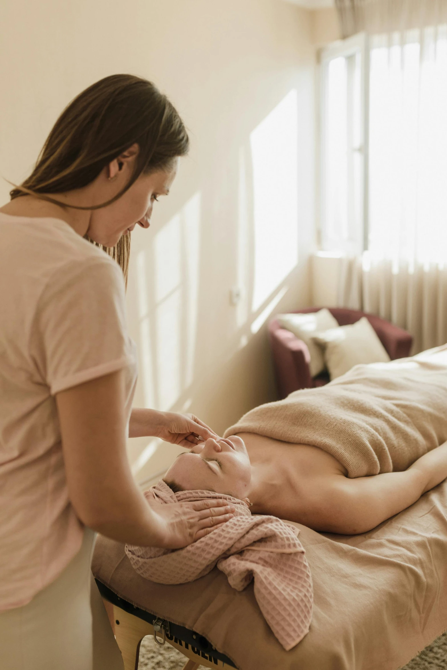 woman in a bedroom getting a neck massage