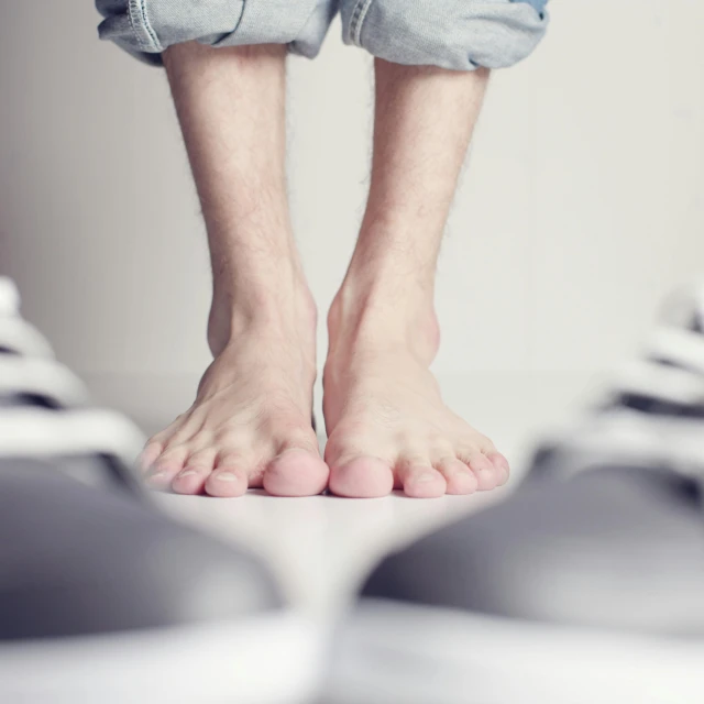 a close up of a persons bare feet in front of a mirror