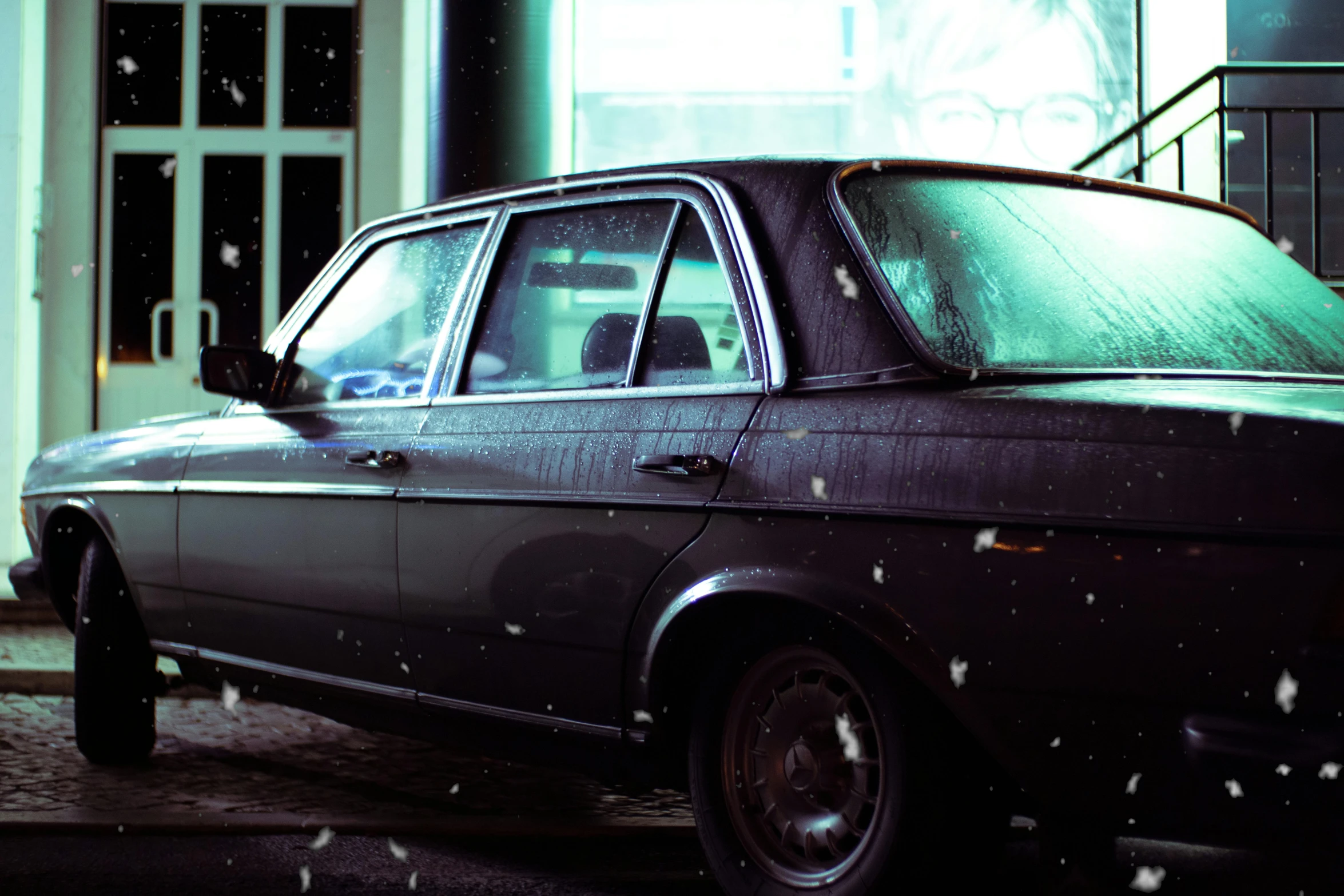 an old - school station wagon sits parked outside of a business building in the snow