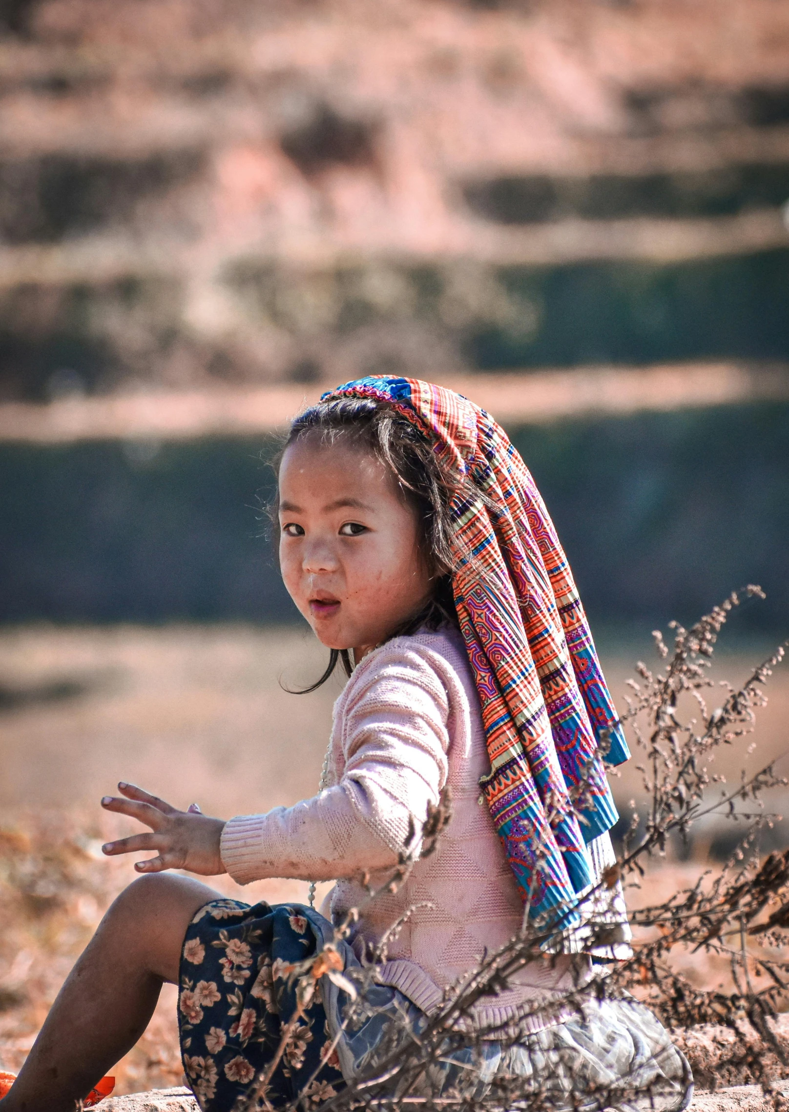 the little girl is playing on the ground with a scar