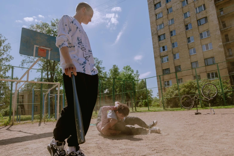 a man holding onto a baseball bat near a basketball net