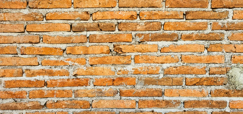 an orange brick wall in front of a brown stone wall