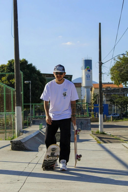 a man holding his skateboard on a road