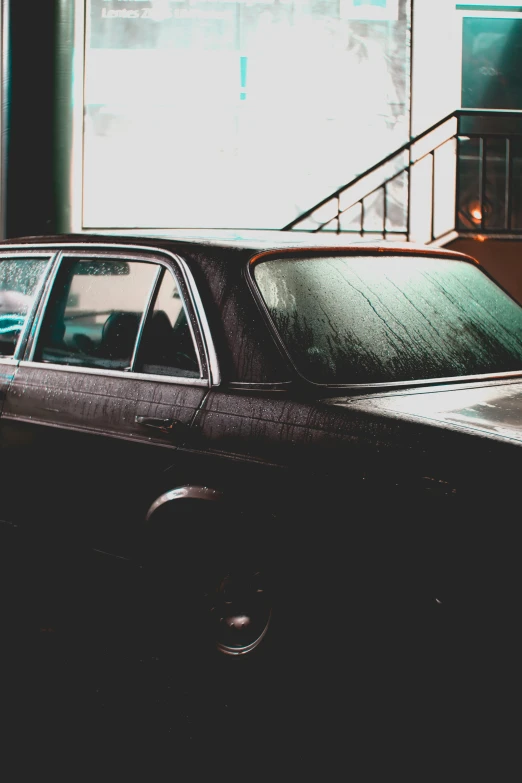 the front of a car with a window partially covered in rain