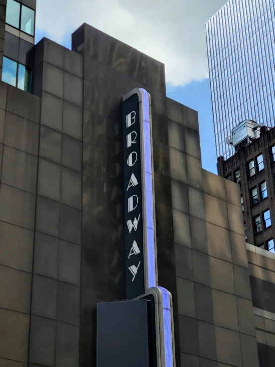 the corner sign is lit up against the backdrop of skyscrs