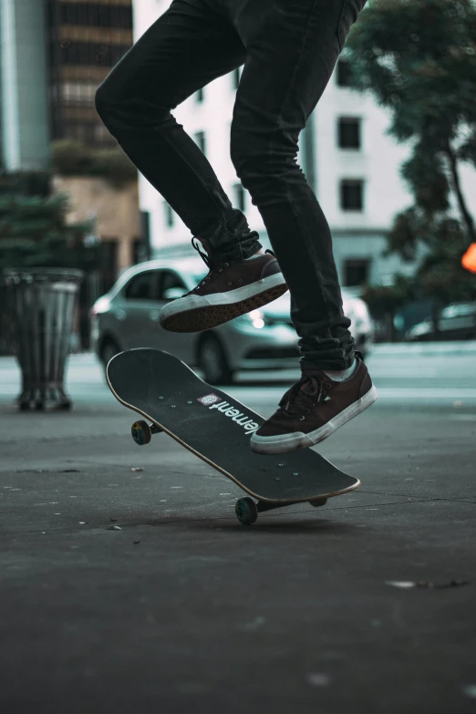 a person wearing red and black sneakers is doing a trick on a skateboard