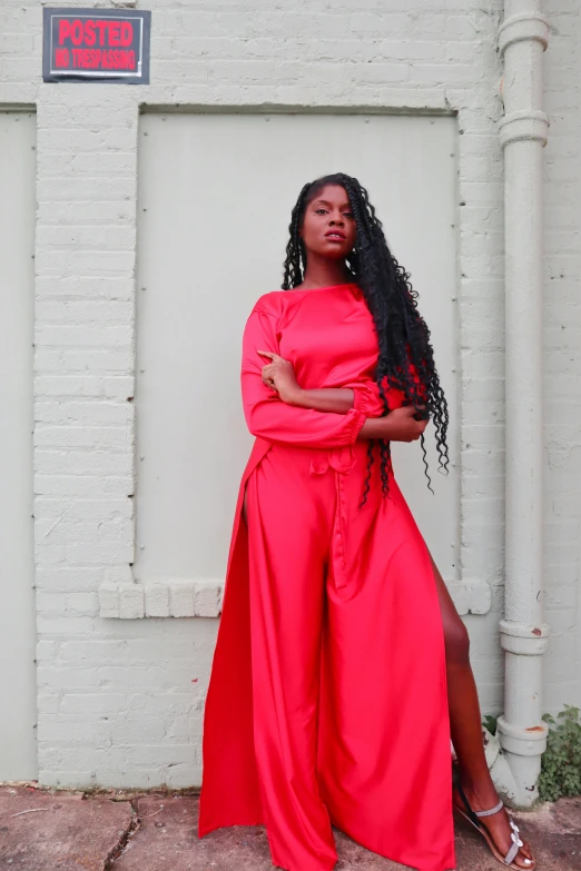 a black woman standing in front of a white brick building