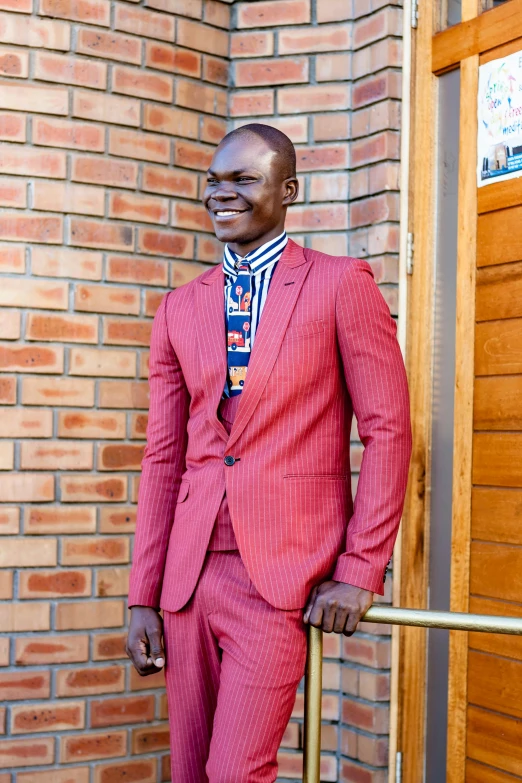 a man in a red suit standing next to a wall