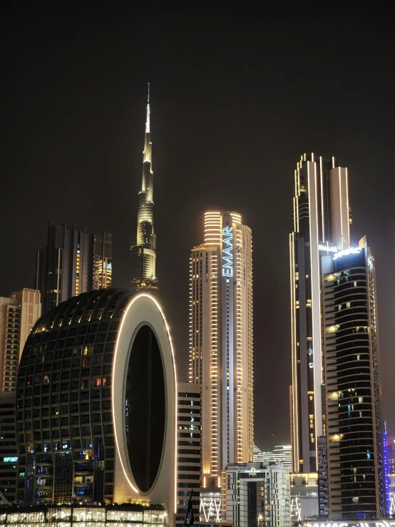 some very large buildings and some lights at night