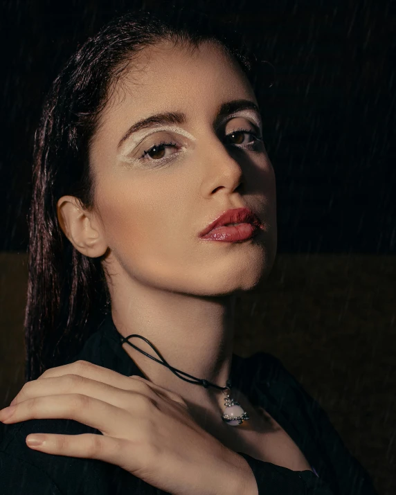 a woman standing in the rain wearing an elegant necklace