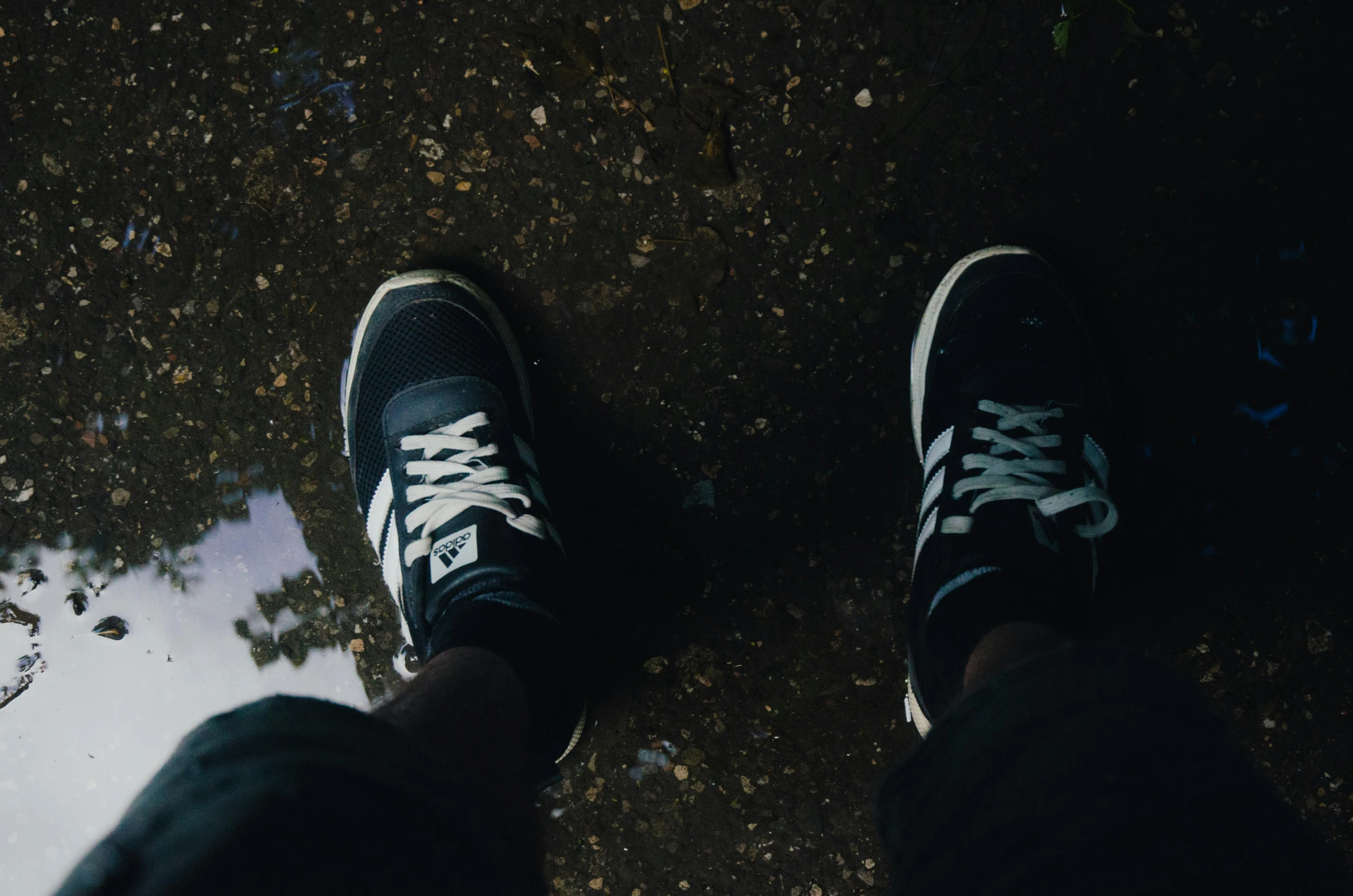 a man in black and white shoes near dle of water