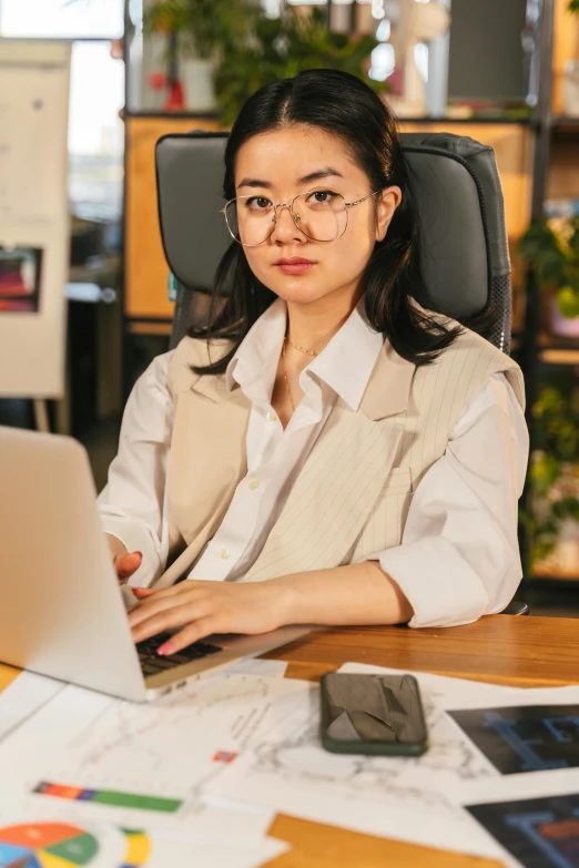 a girl sits at a desk with a laptop computer