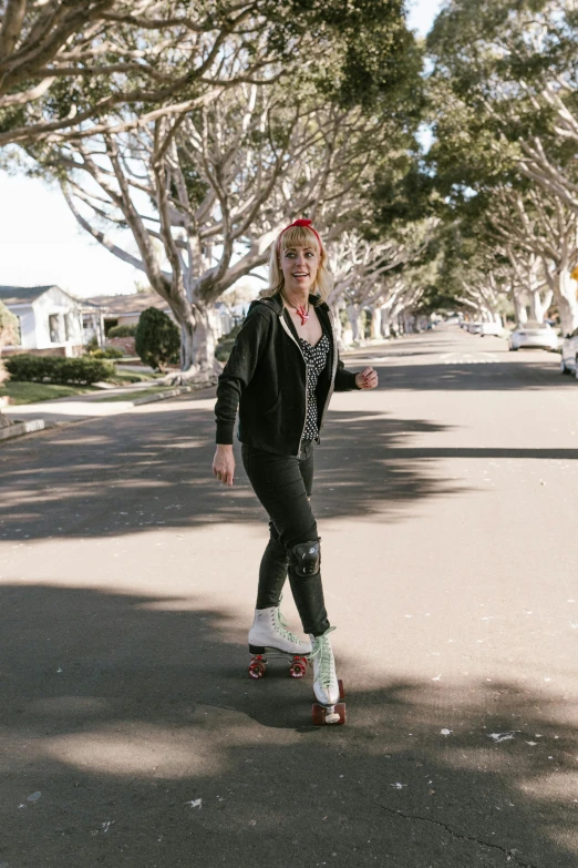 the woman in a black suit is riding on a skateboard