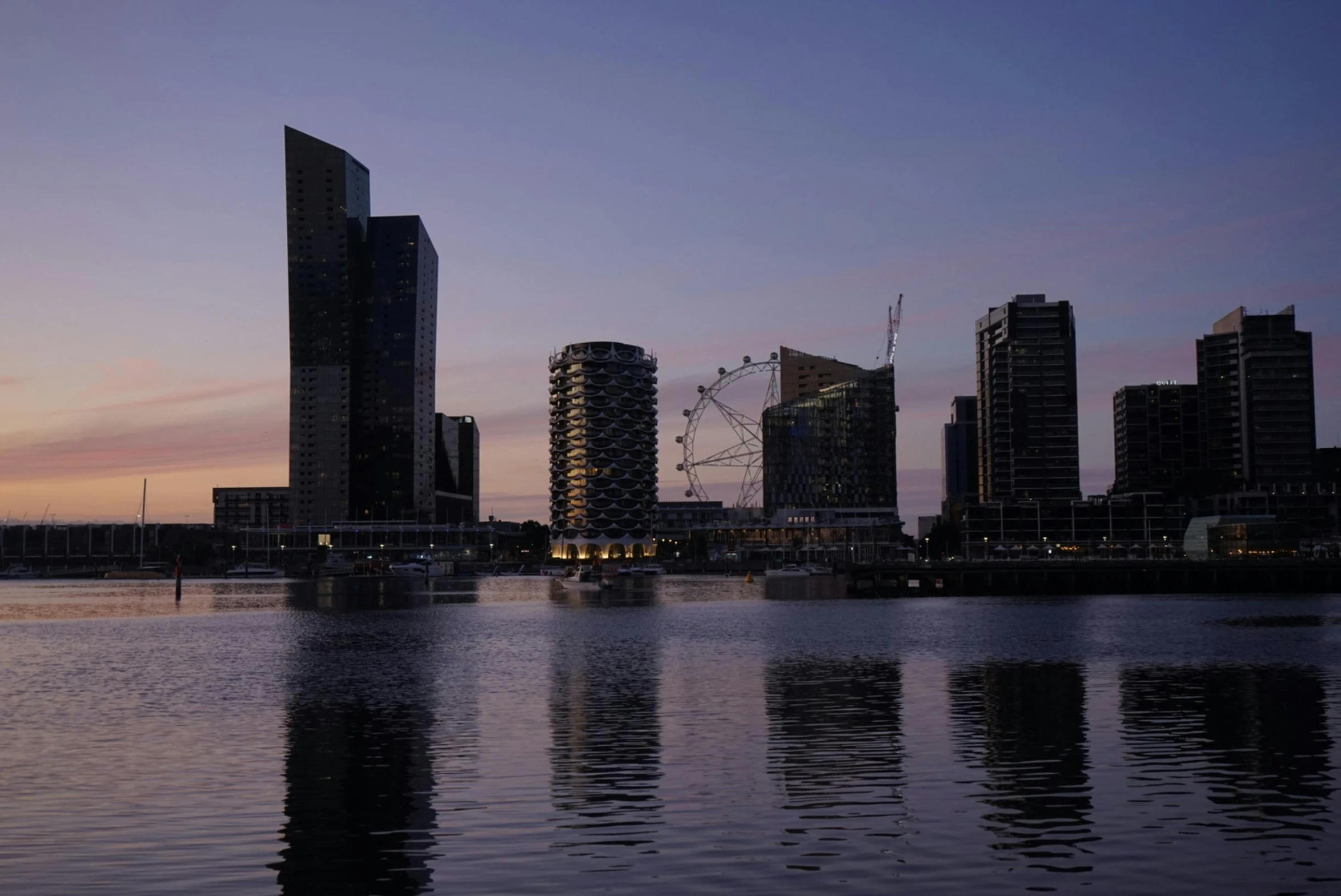 the skyline with tall buildings along the river in the dusk