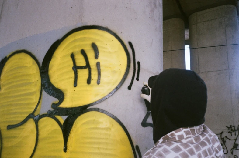 a person using a spray paint knife on a graffiti painted wall