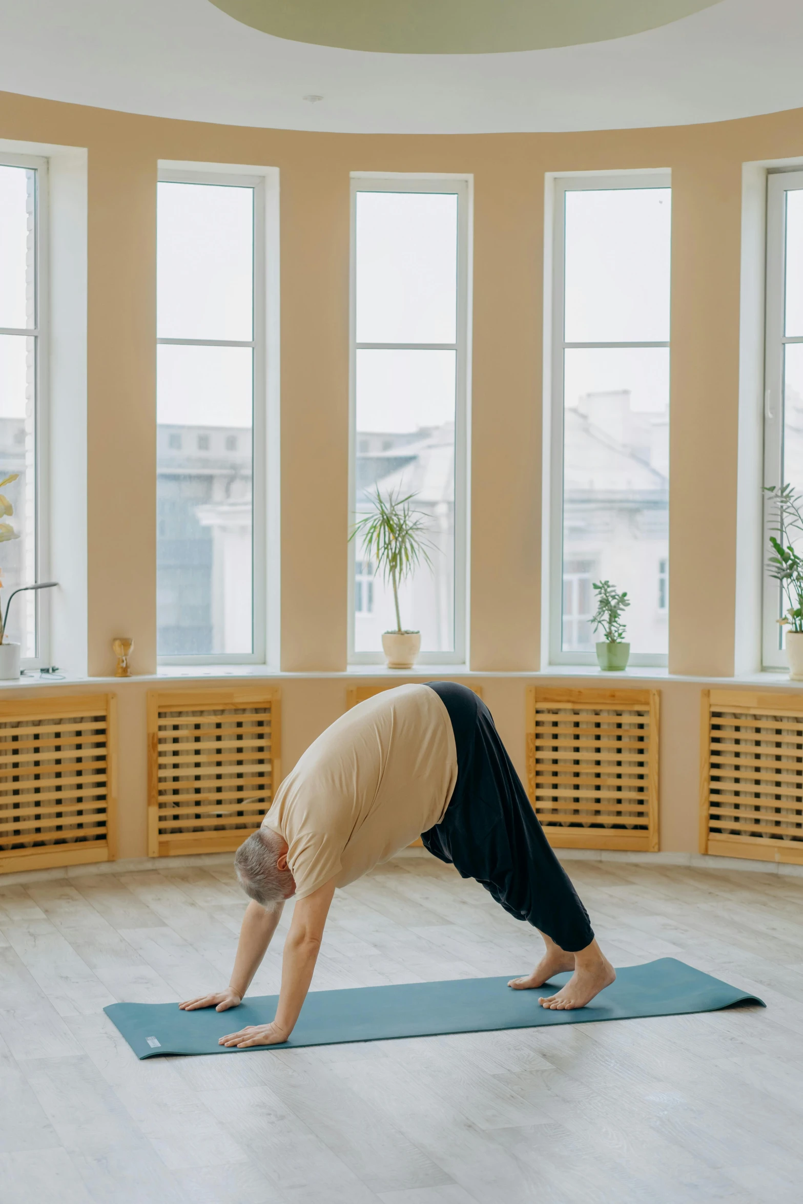 the woman is doing exercises in front of three windows