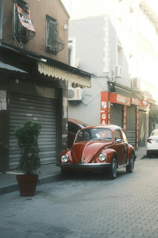 red antique car on bricked city street in city