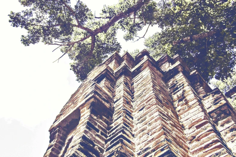 the top of an old stone church with trees