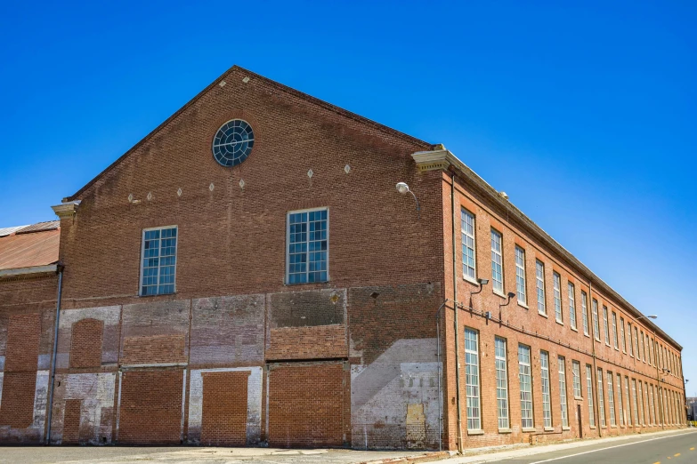 a large brick building has two clocks on it's sides