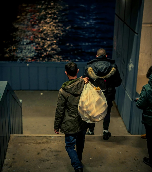 a man in a jacket with a white bag