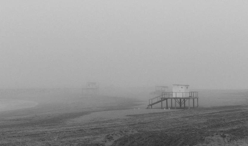 fog hangs over the water tower in a field