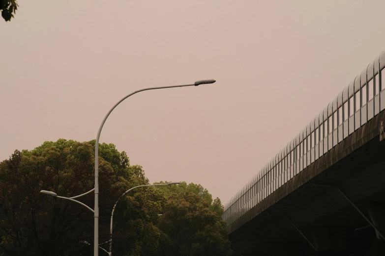 a street light and a large fence and trees