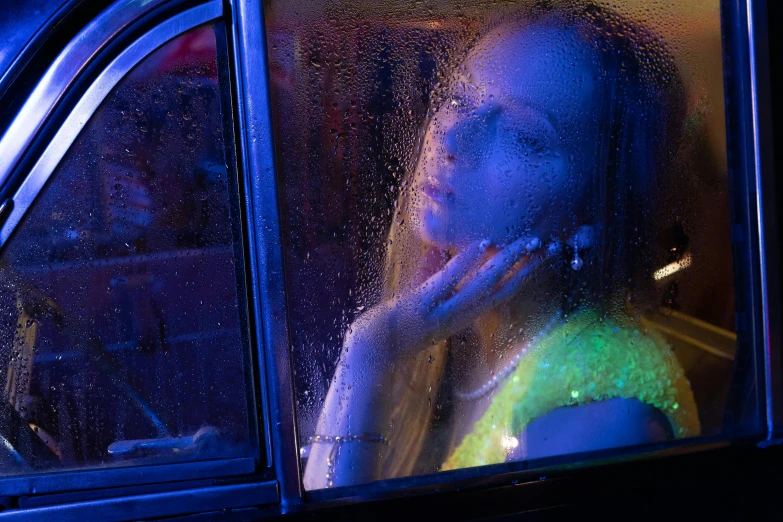 a child sitting in the bus seat with her hand to her face