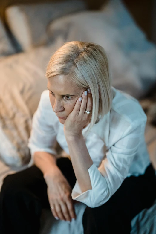 woman sitting on a bed looking off into the distance