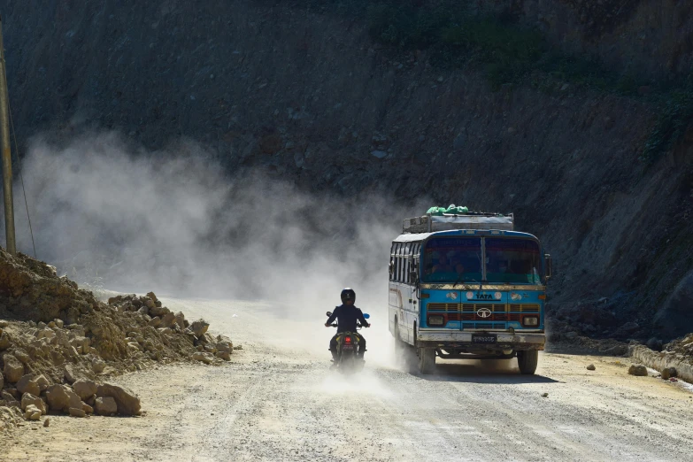 a man on a motorcycle in front of a bus