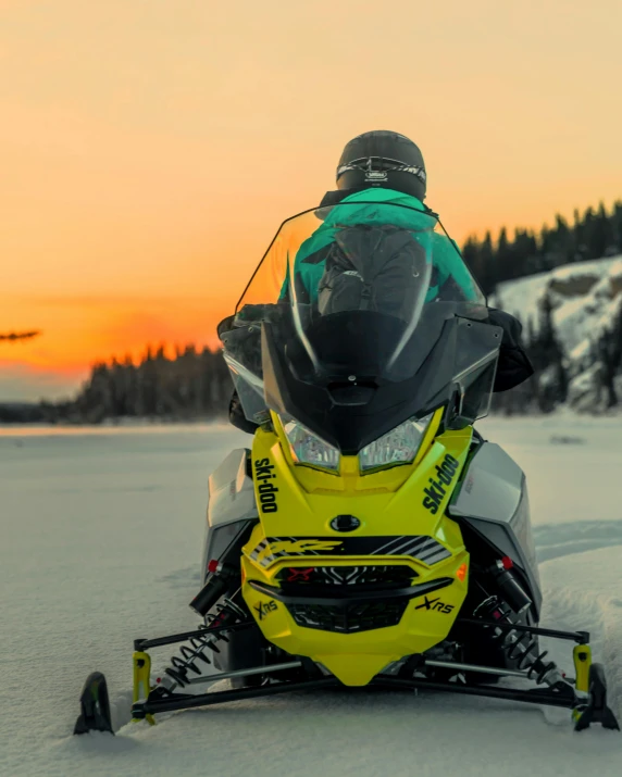 a man in an ice - filled suit is on a yellow snowmobile