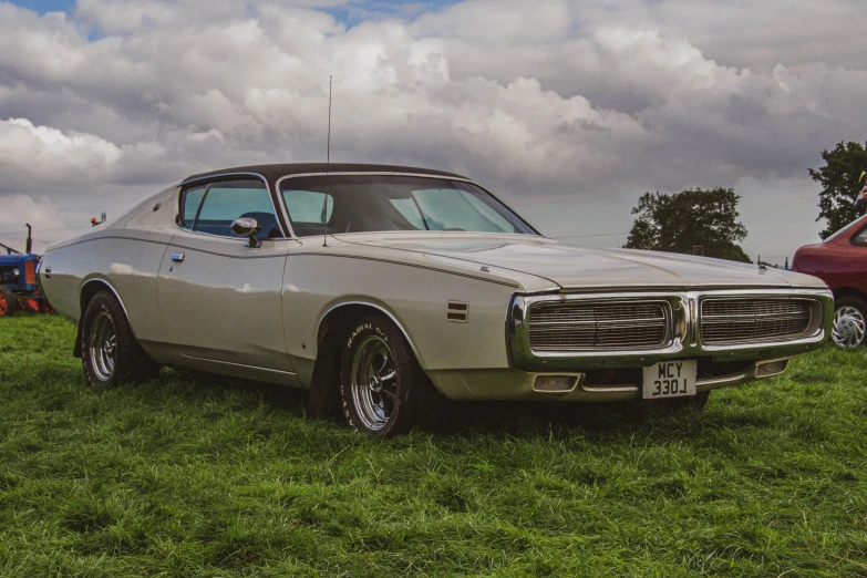 an old car parked on a grassy area next to other cars