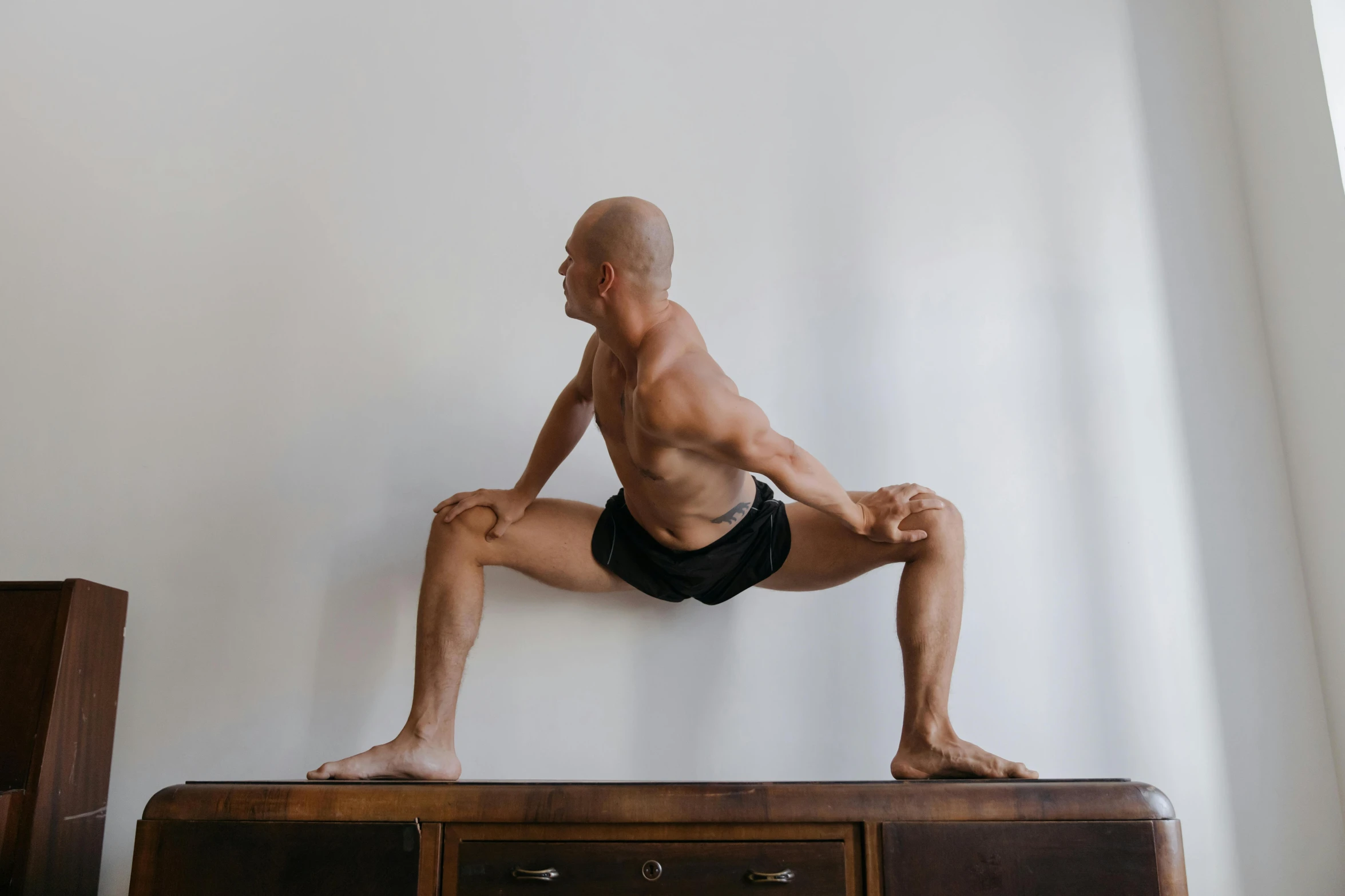 a man is sitting on top of a dresser