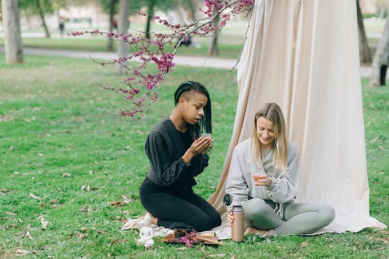 two women having some wine outside in the park