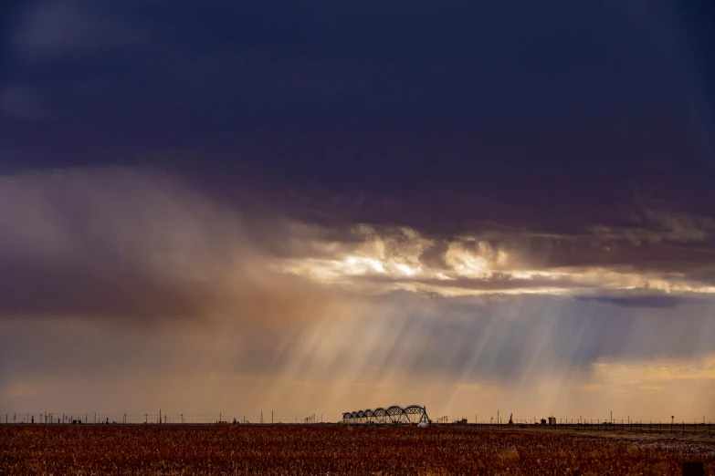 a storm moving in the distance over a barren field